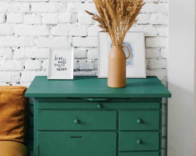 a green table with three drawers and two frames